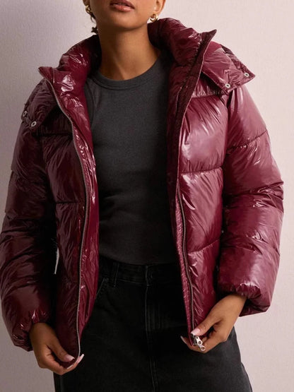 Vatteret jakke med glansfuld finish og praktisk hætte